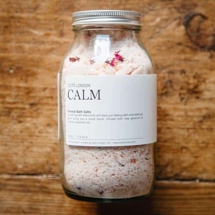 Picture of a jar of Octo's Calm bath salts laying on a wooden background.